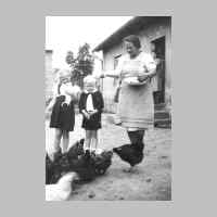 022-0432 Frieda Zimmermann beim Huehnerfuettern im Hof. Die Kinder Dorothea und Gerhard als erstaunte Zuschauer.jpg